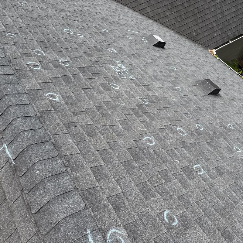 Asphalt shingle roof with hail damage marked for repair