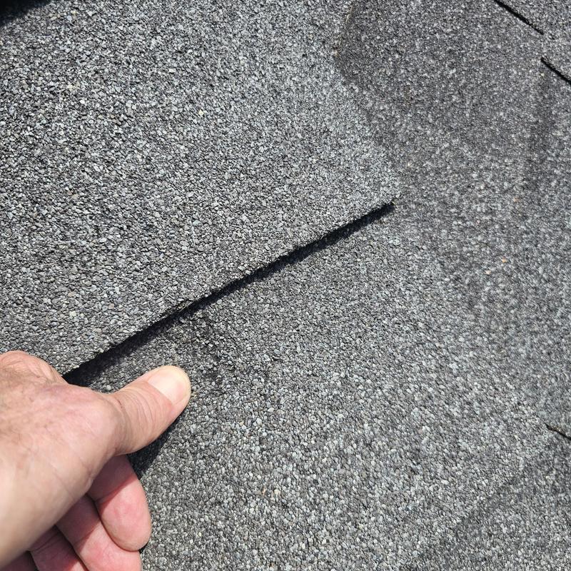Asphalt roof shingles with hail damage close-up