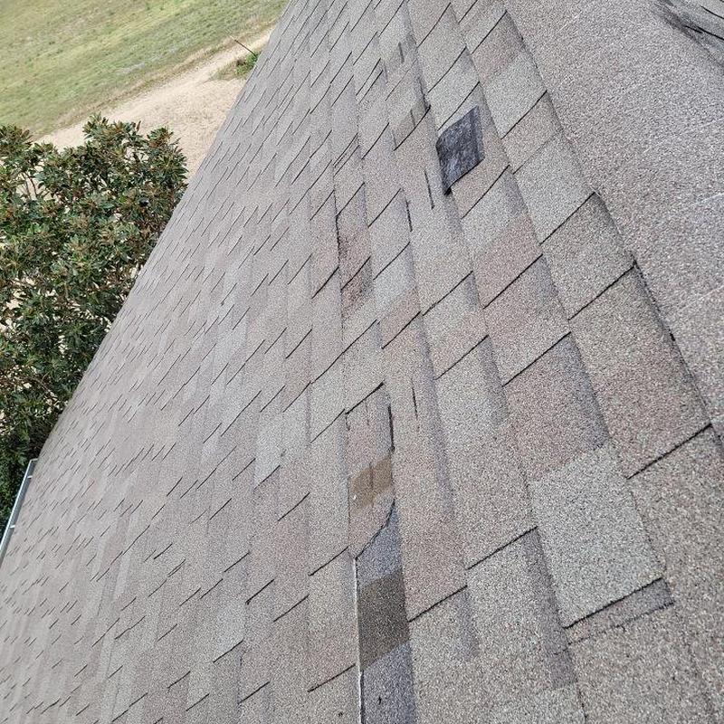 Asphalt shingle roof with storm damage patches