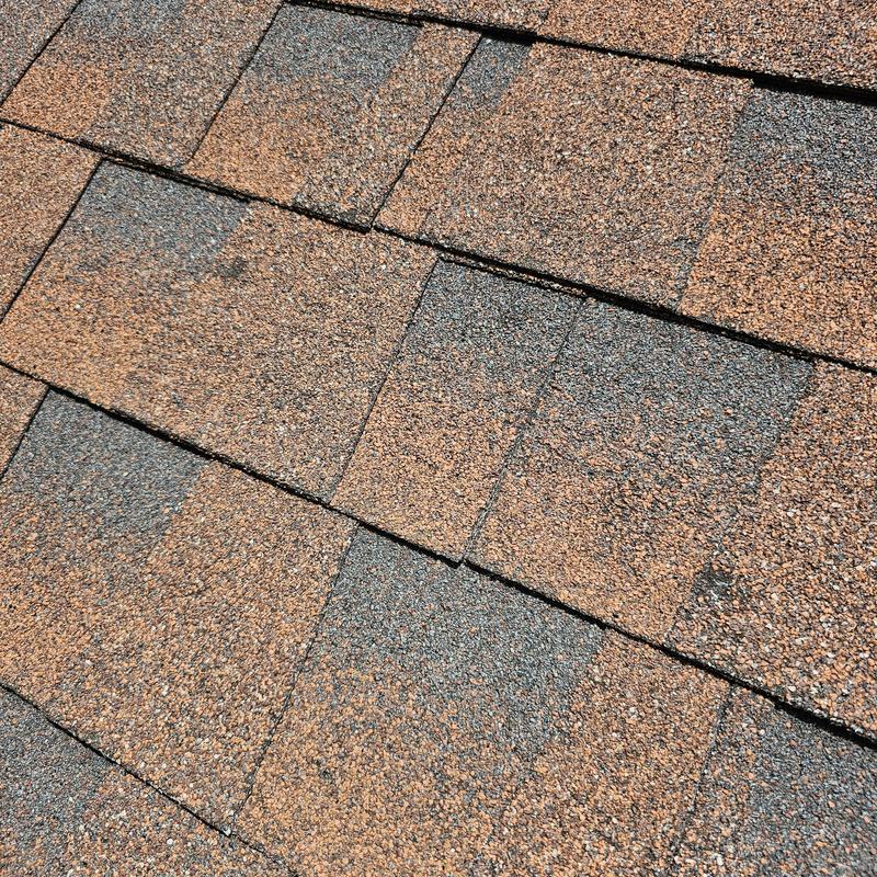Asphalt roof shingles with visible hail damage close-up