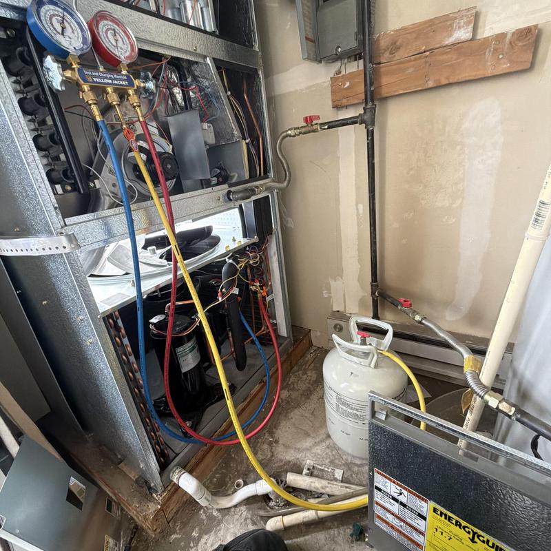 HVAC refrigerant gauges connected to furnace unit