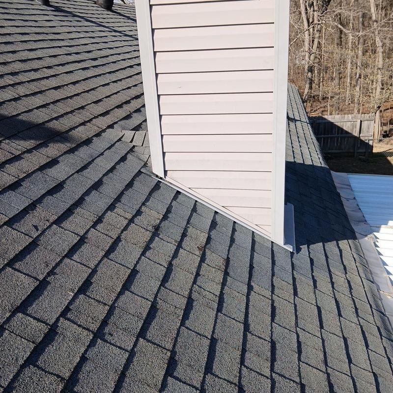 Chimney flashing and roof shingles on residential house