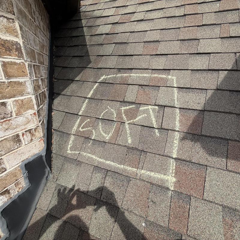Roof shingles soft spot marked near wall flashing