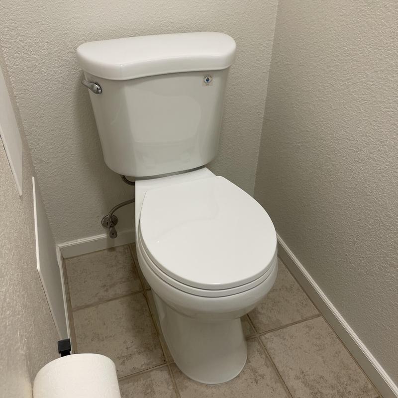 Upstairs toilet with closed lid in bathroom corner