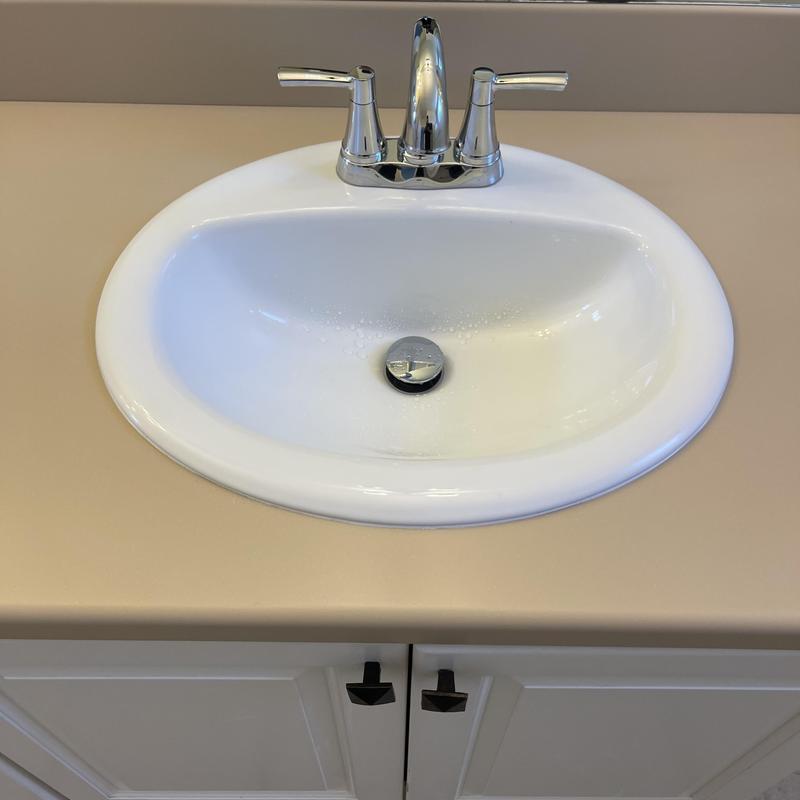 Bathroom sink and chrome faucet with stopper installed