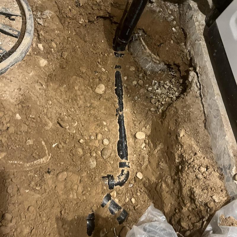 Sewage ejection pump basin pipe installation in soil trench