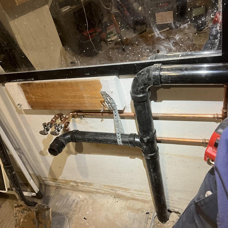 Sewage ejection pump basin and connected plumbing installation