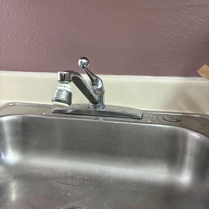 Kitchen faucet installed over stainless steel sink