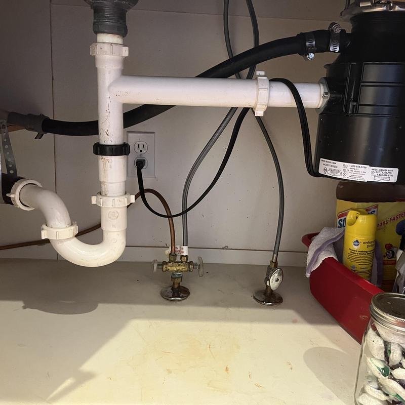 Kitchen sink drain pipes and garbage disposal under cabinet