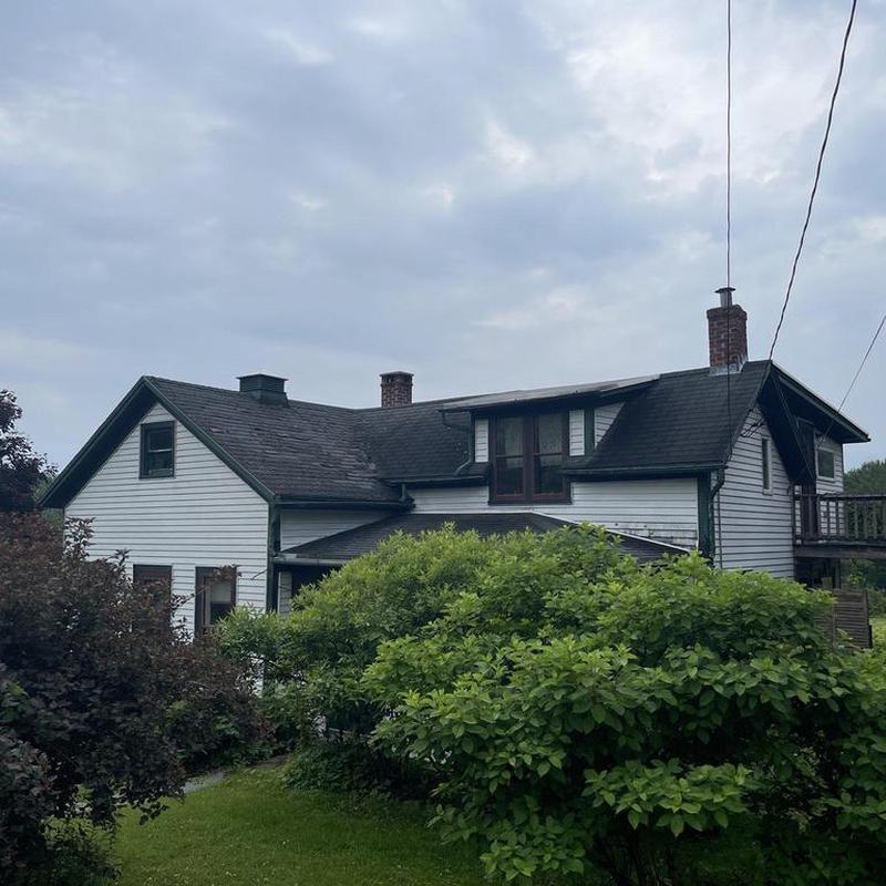 Asphalt shingle roof on two-story white house Asphalt shingle roof on two-story white house