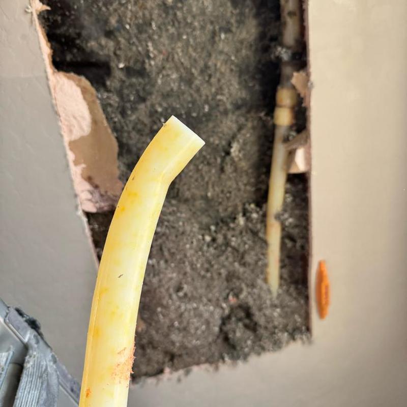 PEX pipe with strain-caused leak from hard bend in wall corner