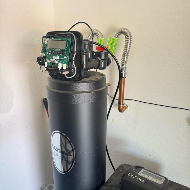 Water softener with exposed control panel and piping