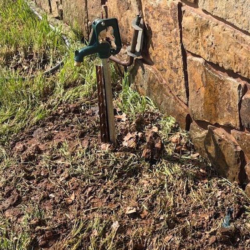 Bury hydrant installed near stone wall in yard