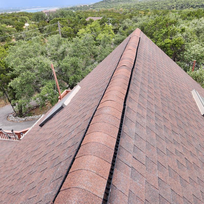 Asphalt shingle roof ridge and shingles with visible wear Asphalt shingle roof ridge and shingles with visible wear