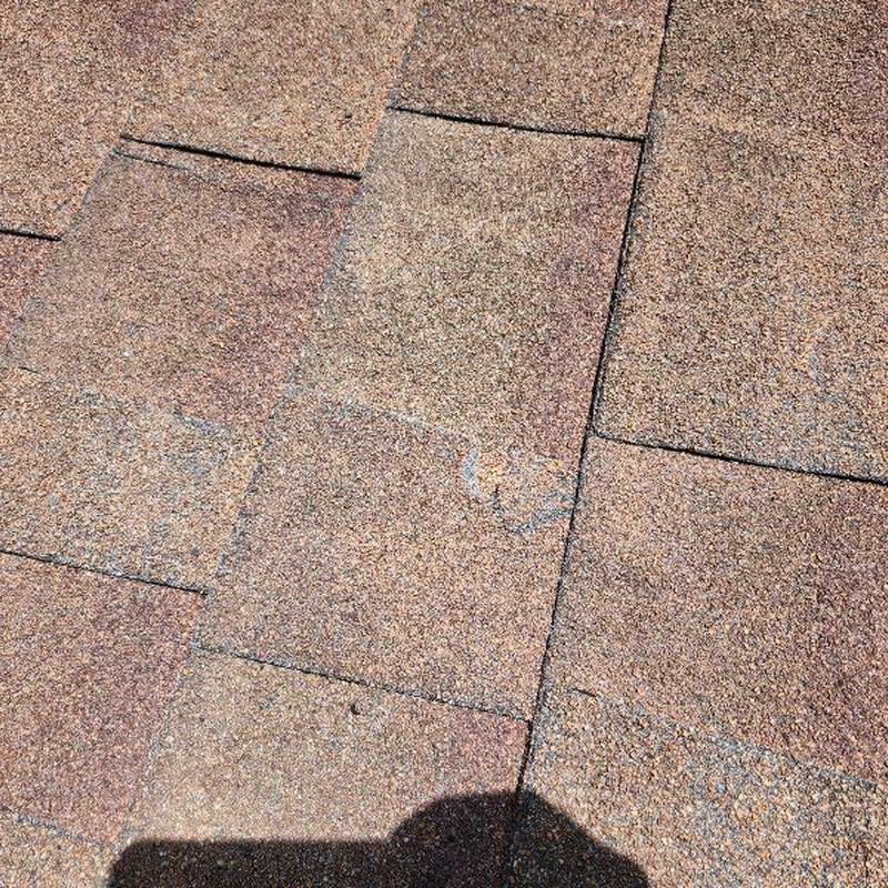 Asphalt roof shingles with cracks and granular loss Asphalt roof shingles with cracks and granular loss