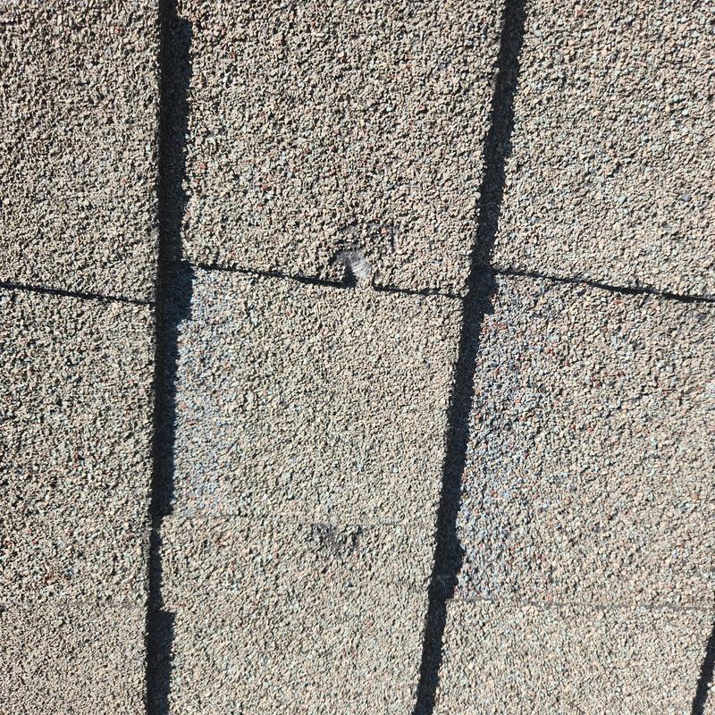 Roof shingles with hail and granular damage close-up Roof shingles with hail and granular damage close-up