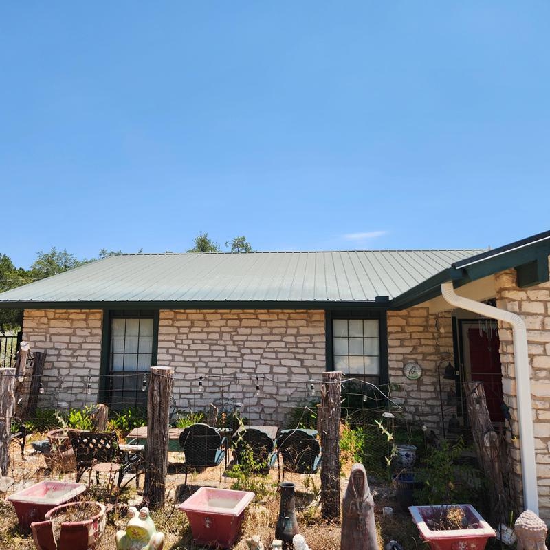 Standing seam galvalume metal roof on stone house Standing seam galvalume metal roof on stone house