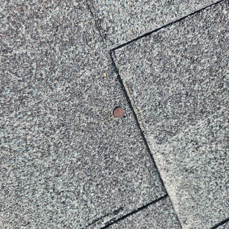 Asphalt roof shingle with exposed nail and lifting edges