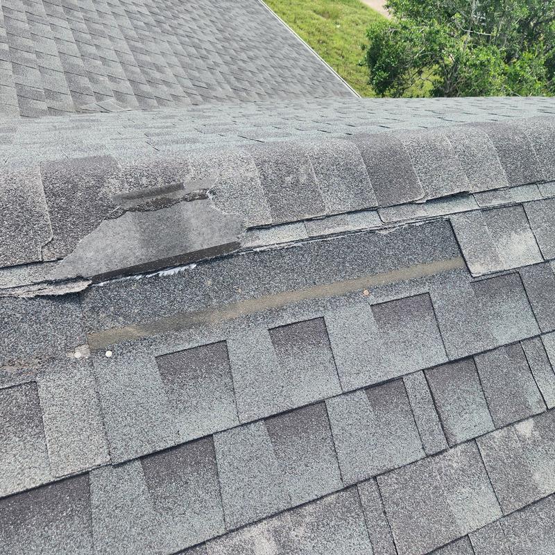 Roof shingles damaged with lifted flashing and nail pop