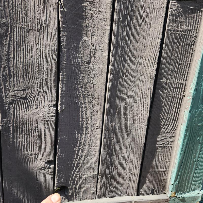 Wood siding close-up with damage near door threshold