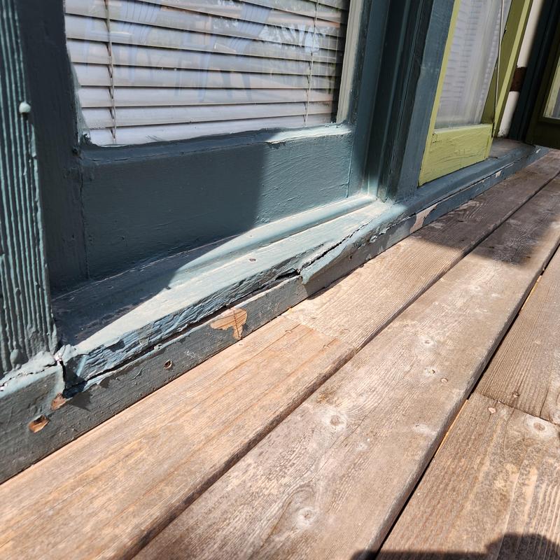 Wood door threshold and siding with water damage