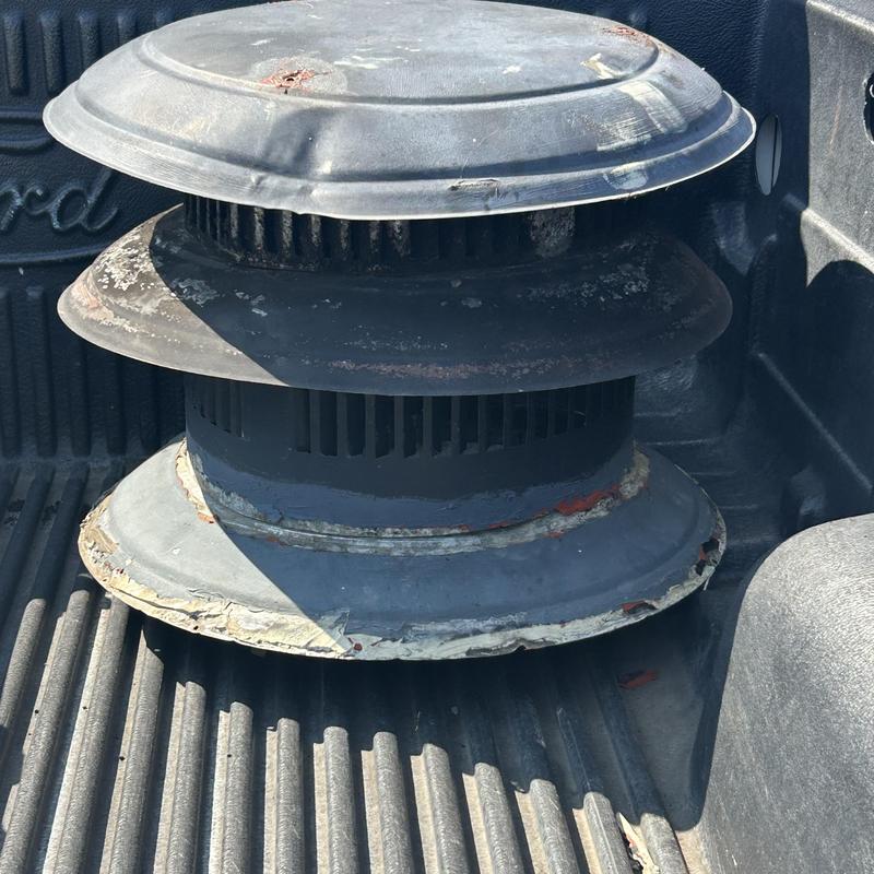 Chimney cap with rust and sealant residue in truck bed