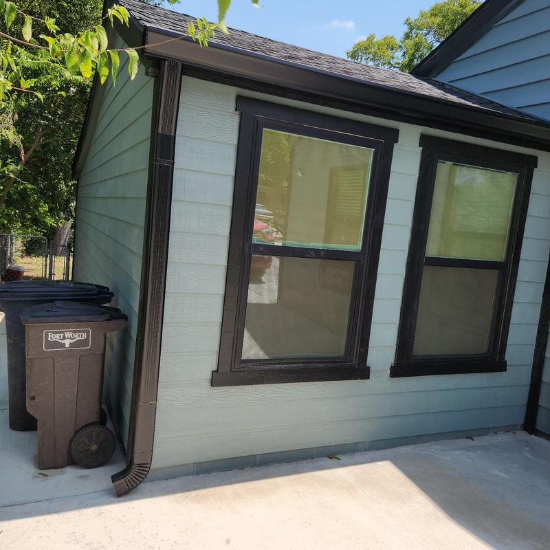 Black aluminum gutter and downspout on house exterior