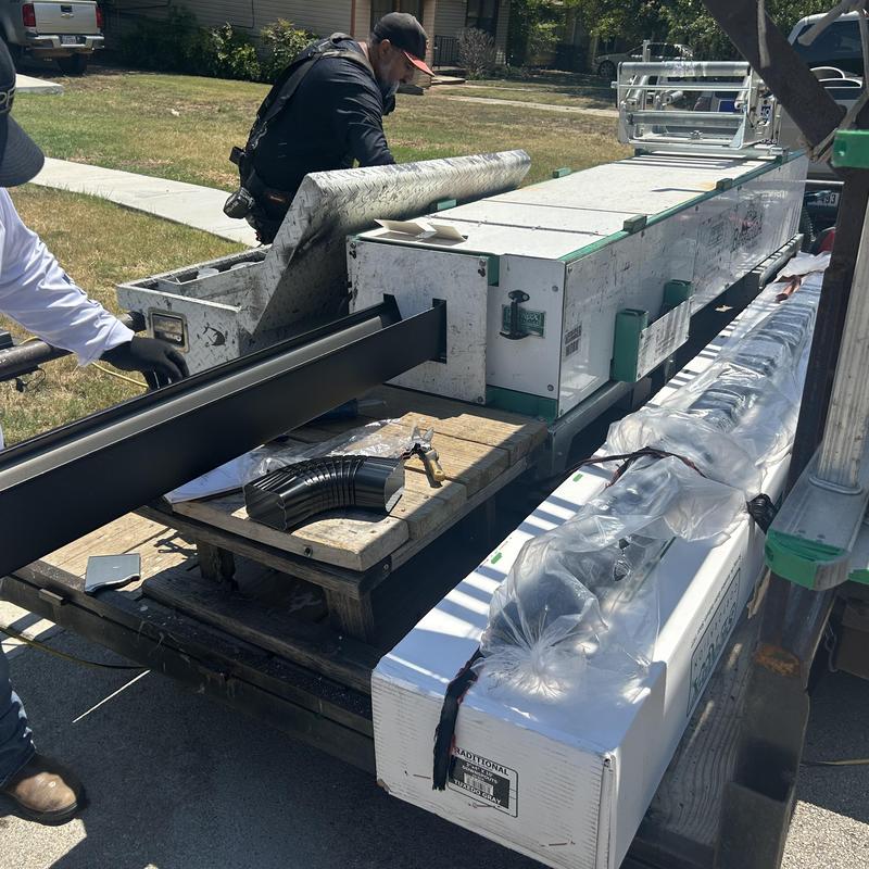 Black gutters and downspouts with installation tools