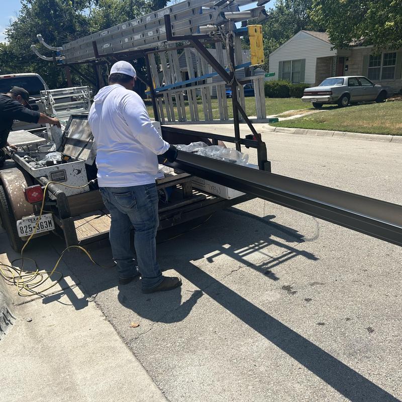 Black gutter section loading onto trailer in Fort Worth