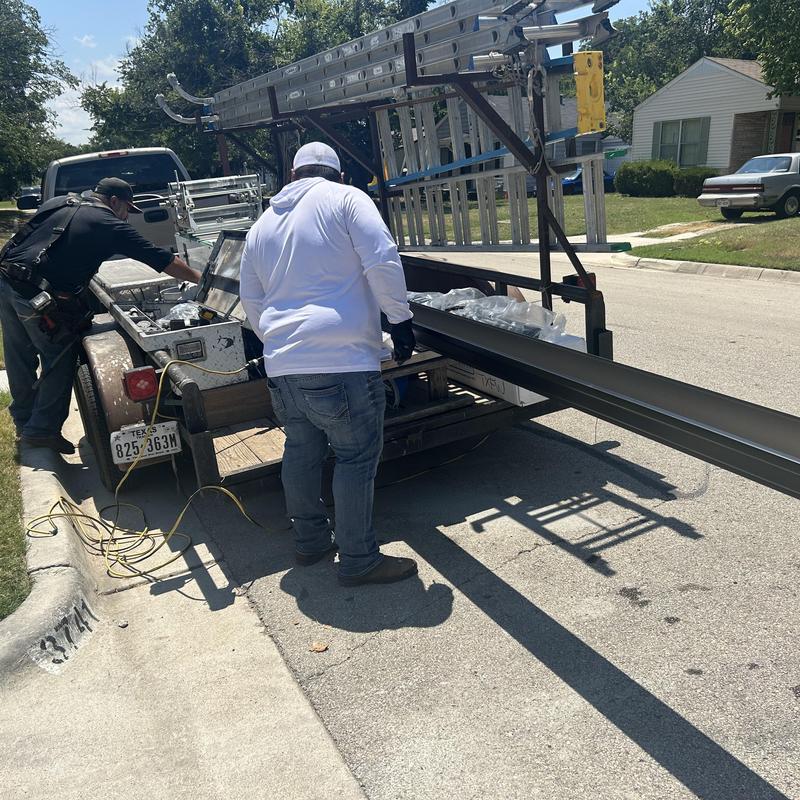 Black aluminum gutters loading on trailer in Fort Worth job