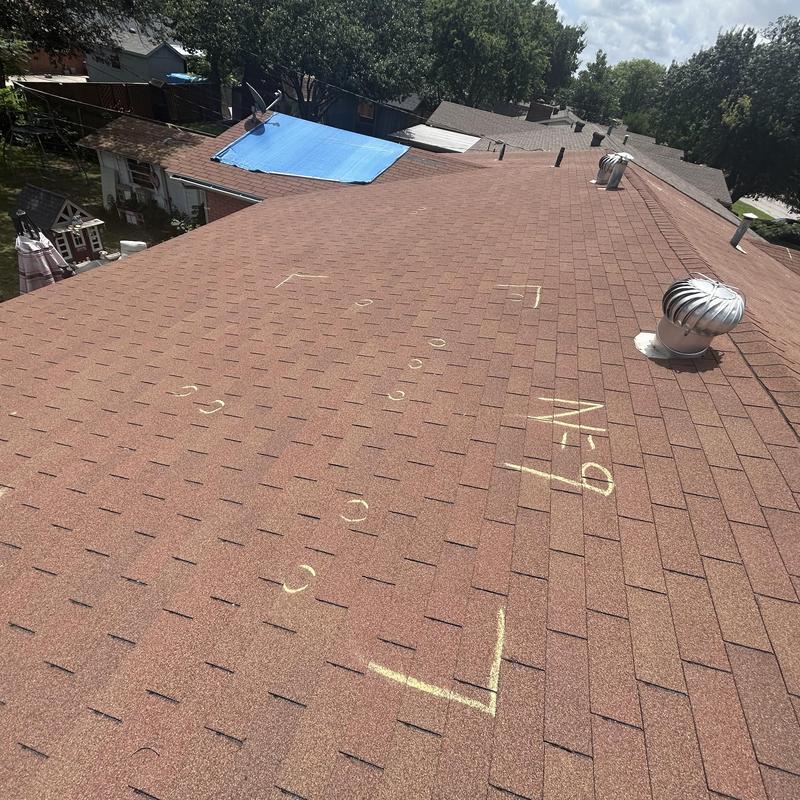 Asphalt shingle roof with chalk markings during inspection