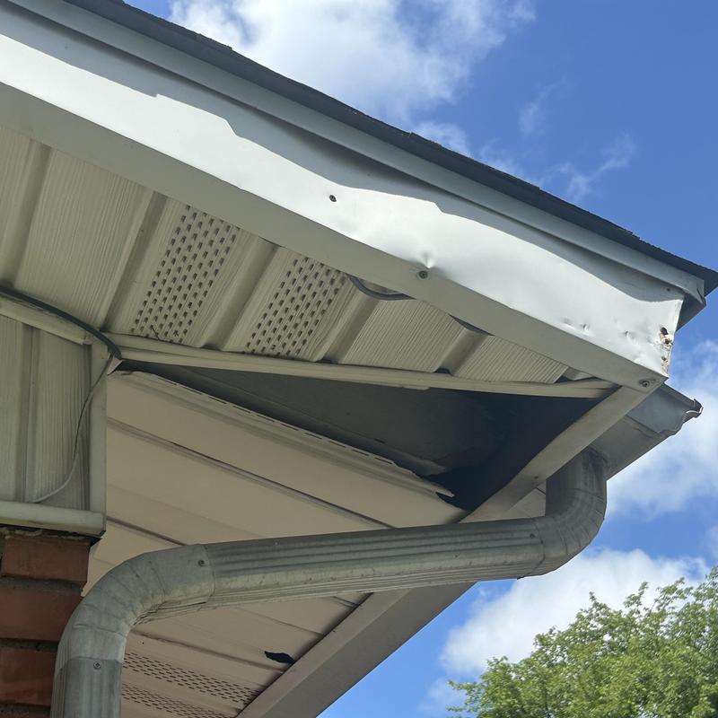 Damaged soffit siding and bent gutter system under roof edge