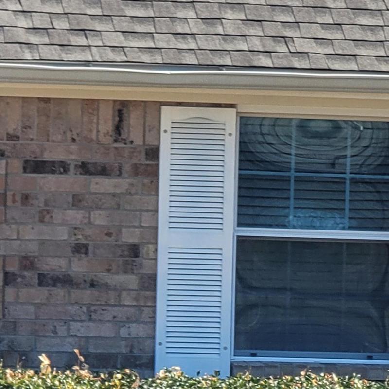 Roof shingles with hail damage near window and gutter