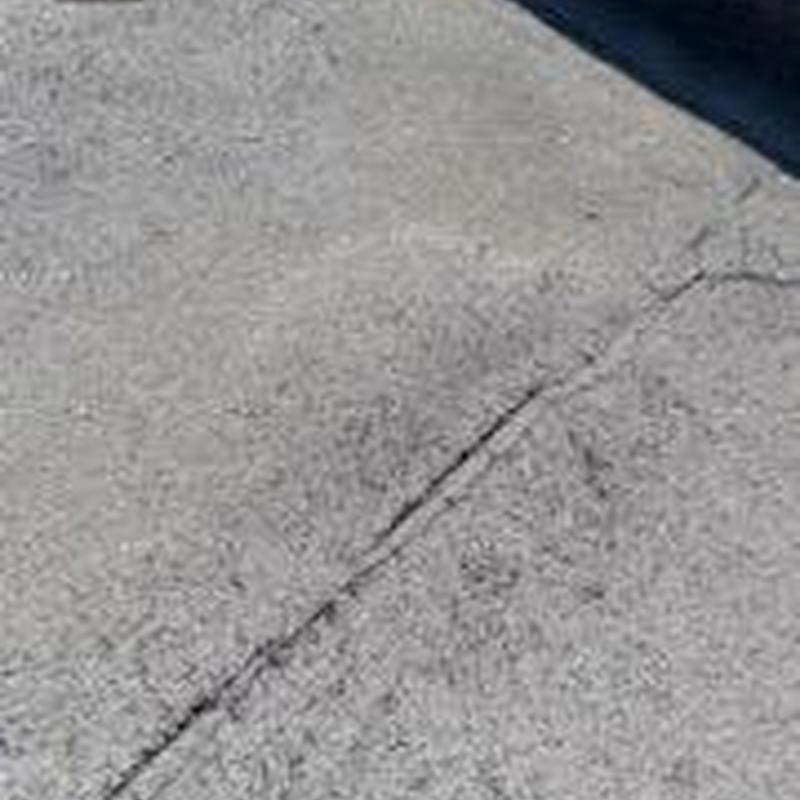 Concrete driveway with crack from hail damage