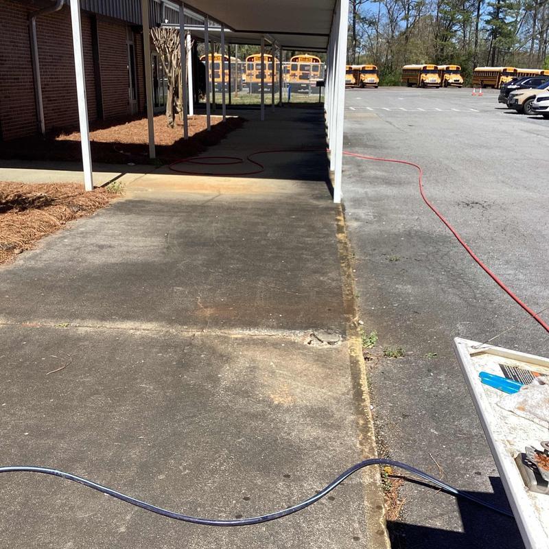 Main sewer line jetting hose on school pavement