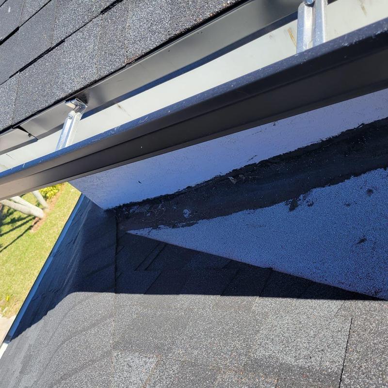 Shingle roof and gutter corner showing minor repairs