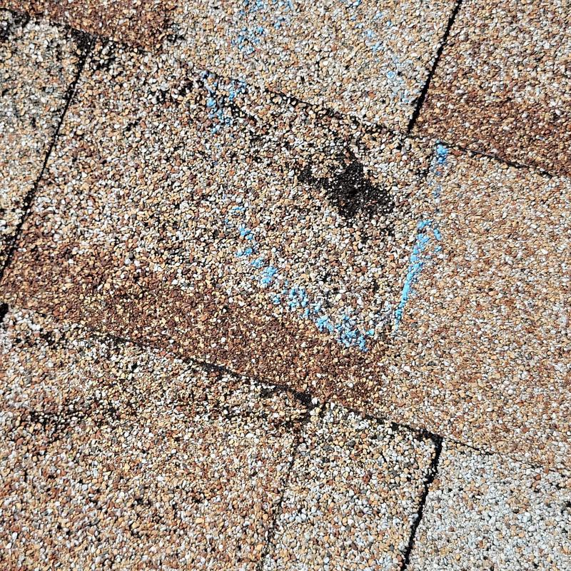 Shingle roof with marked damaged granules close-up
