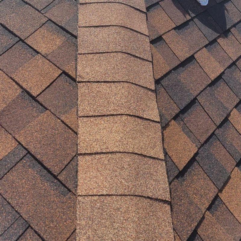 Asphalt shingle hip cap with previous repair issues