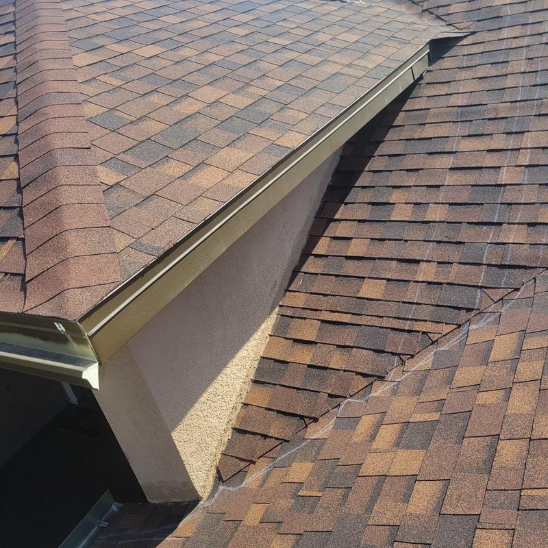 Shingle roof with damaged hip cap and failing repairs