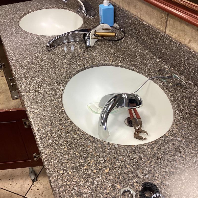 Bathroom sink faucet installation with tools in basin