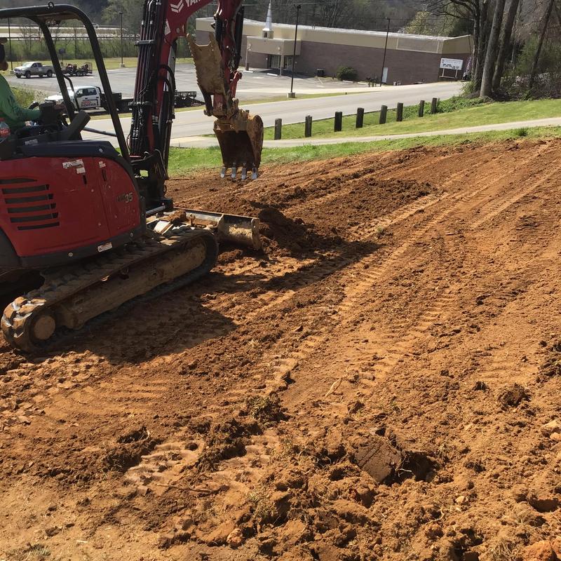 Field lines installation with excavator in front yard