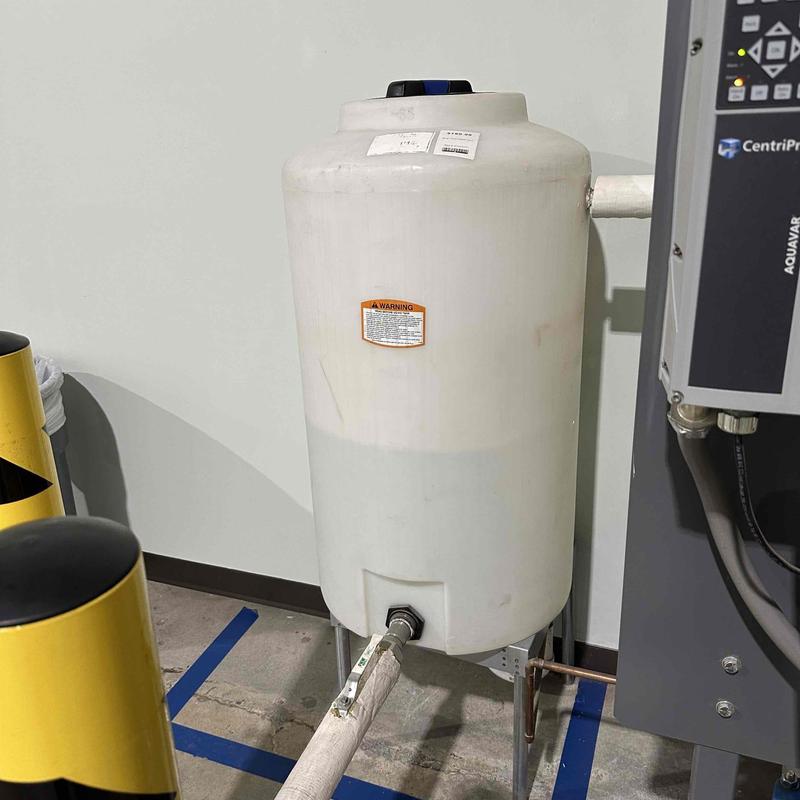 Expansion tank with pipe connection in industrial setting