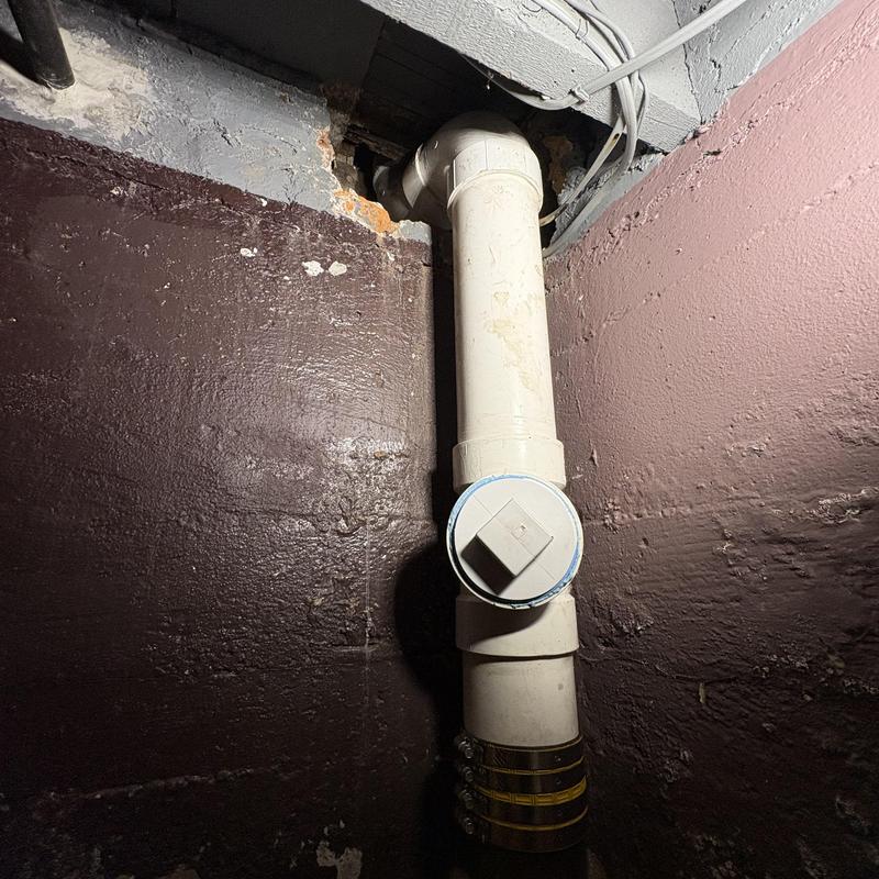 4-inch PVC pipe replacing cast-iron stack in basement wall