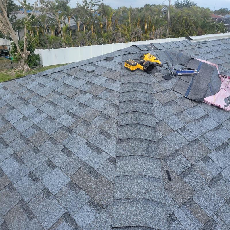 Shingle roof ridge with repair tools in Cape Coral
