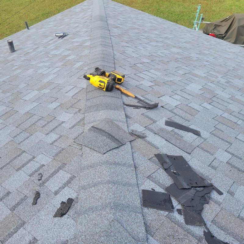 Shingle roof with tools and removed damaged shingles
