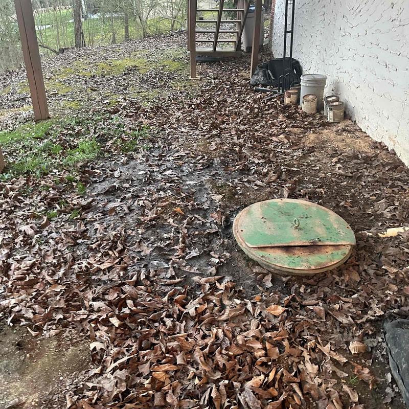 Pump vessel cover beside white brick wall outdoors