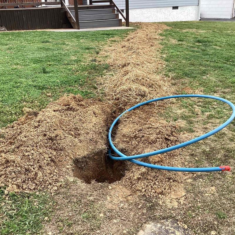 Water line trench with blue piping for replacement work