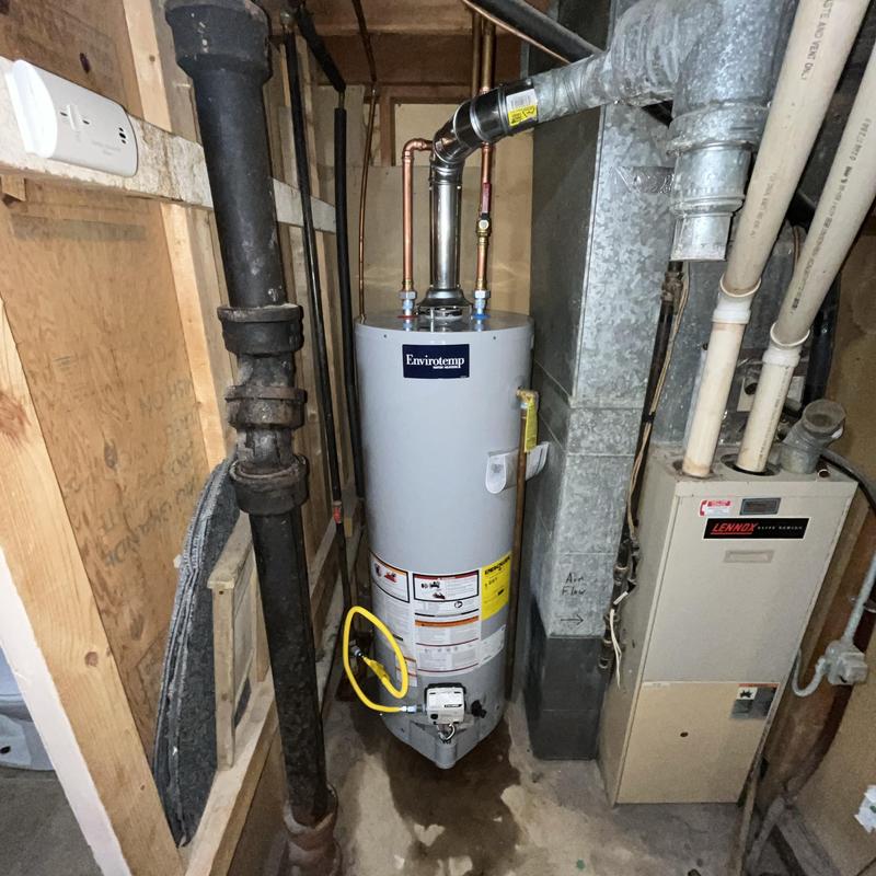Gas water heater installation with vent pipe and furnace nearby