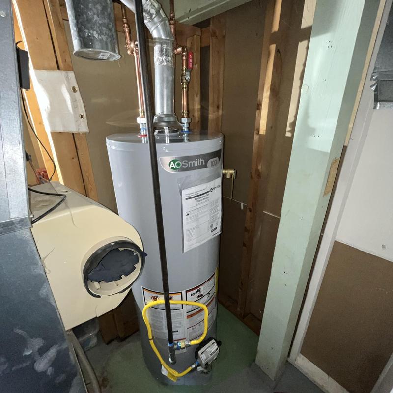 Gas water heater with vent and piping in basement