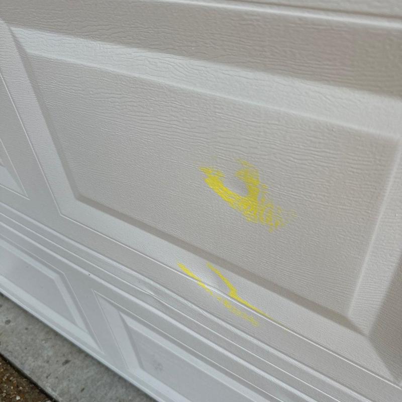 Garage door panel with yellow paint marks
